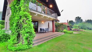 A two-story house with a balcony, a covered patio, and a small shed. - Comfortable, Large Holiday Home With a Garden (Malechowo)