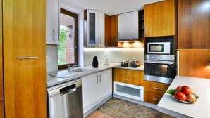A modern kitchen with stainless steel appliances, wooden cabinets, and a tiled backsplash. - Comfortable, Large Holiday Home With a Garden (Malechowo)