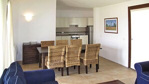 Una sala de estar con sofá, una mesa de centro y un comedor con mesa y sillas.