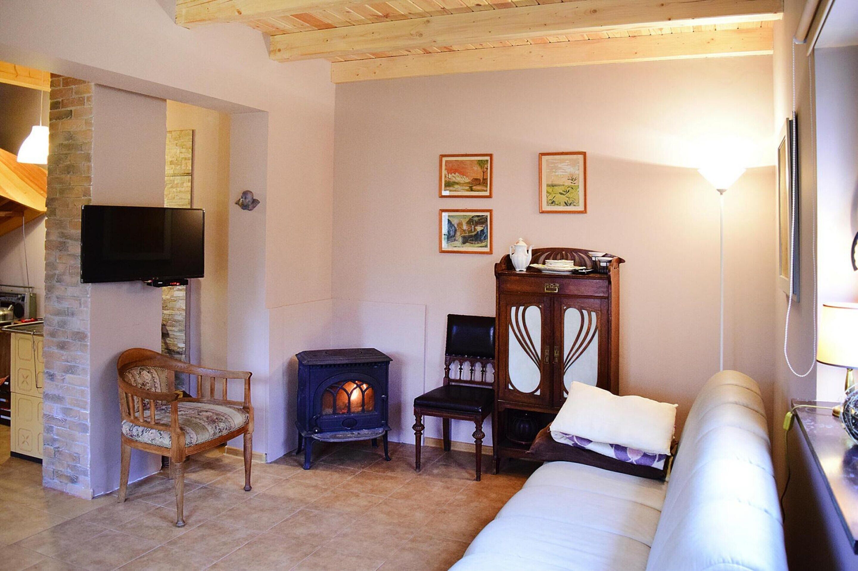 Una habitación acogedora con chimenea, televisor, sofá y un mueble de madera.