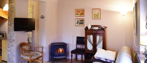 Una habitación acogedora con chimenea, televisor, sofá y un mueble de madera.
