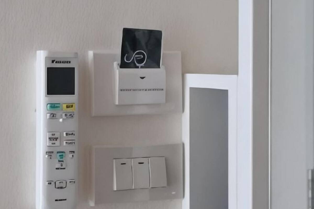 Ein Bedienfeld mit digitaler Anzeige, einem Taschentuchspender und mehreren Wandleuchtschaltern.