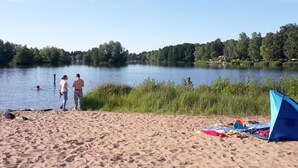 Una playa con una carpa y un lago tranquilo.