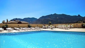 Piscina con lettini e vista sulle montagne.