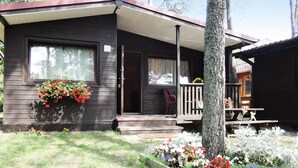 A small, single-story cabin with a porch and a covered patio area. - Holiday Resort in Dziwnowek - Polaris by the sea (Dziwnów)