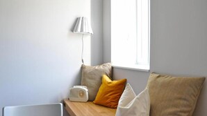A room with a wooden bench, a table, and a window with a view.