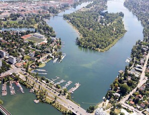 An aerial view of a riverside town with a marina, residential areas, and a bridge connecting two parts of the town.