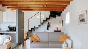 A modern living room with a sofa, a small table, and a staircase leading to the upper floor. - Residence Nautic Resort San Carlo, Gargnano (Gargnano)