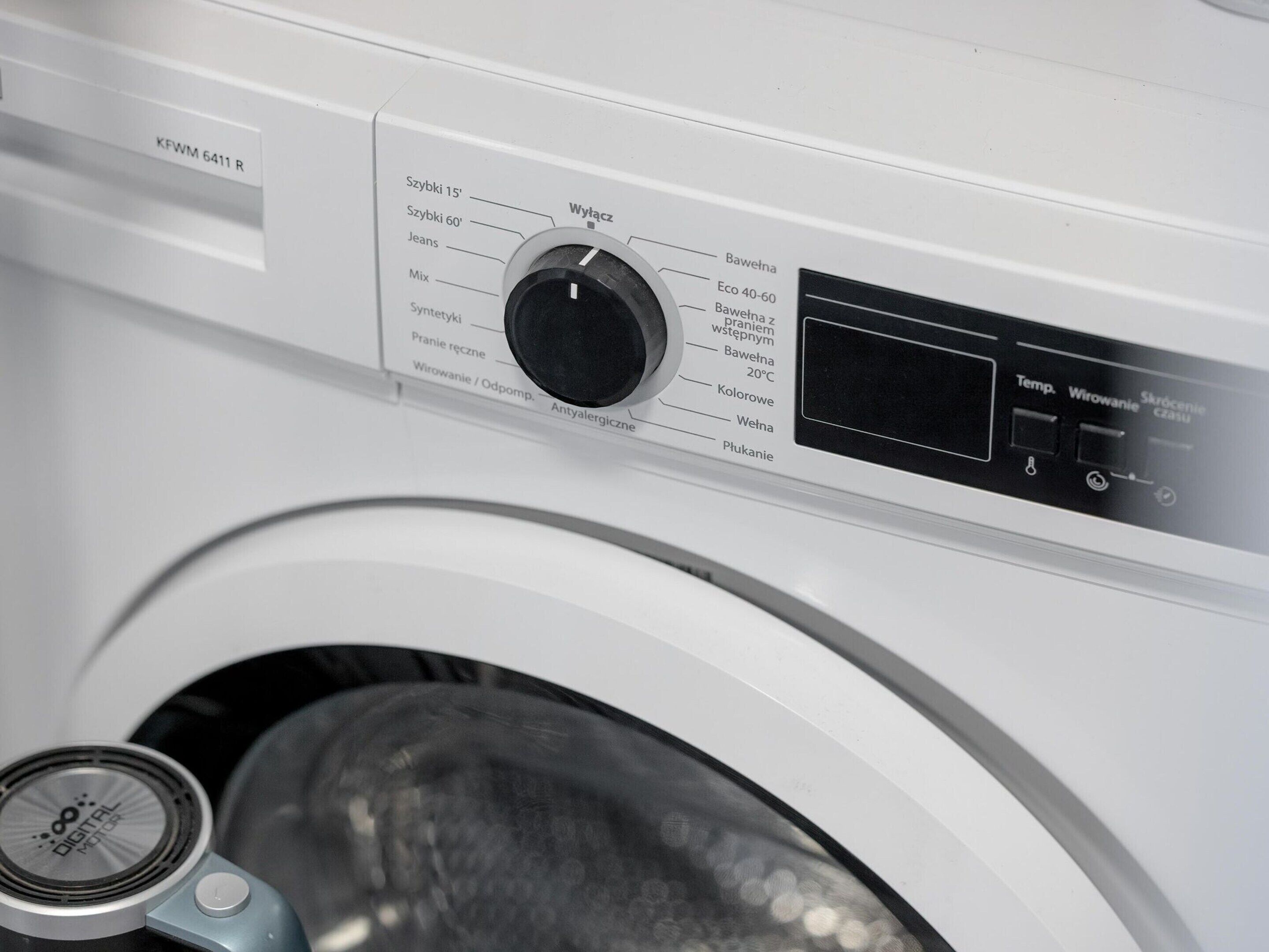 A front view of a washing machine with a control panel displaying various settings and a digital display.