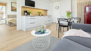 Un apartamento moderno con kitchenette, comedor y sala de estar.