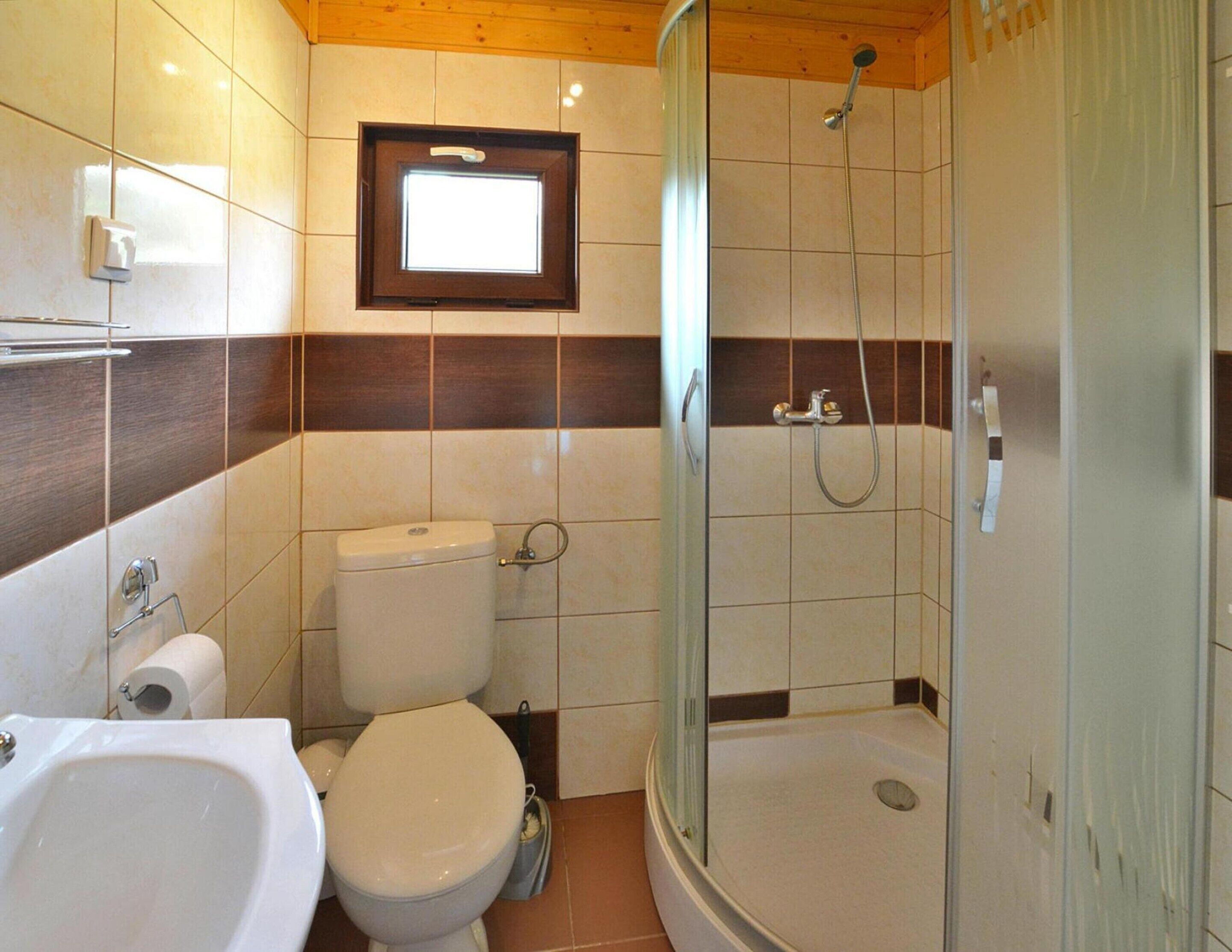 A bathroom with a toilet, bidet, sink, and a glass-enclosed shower.