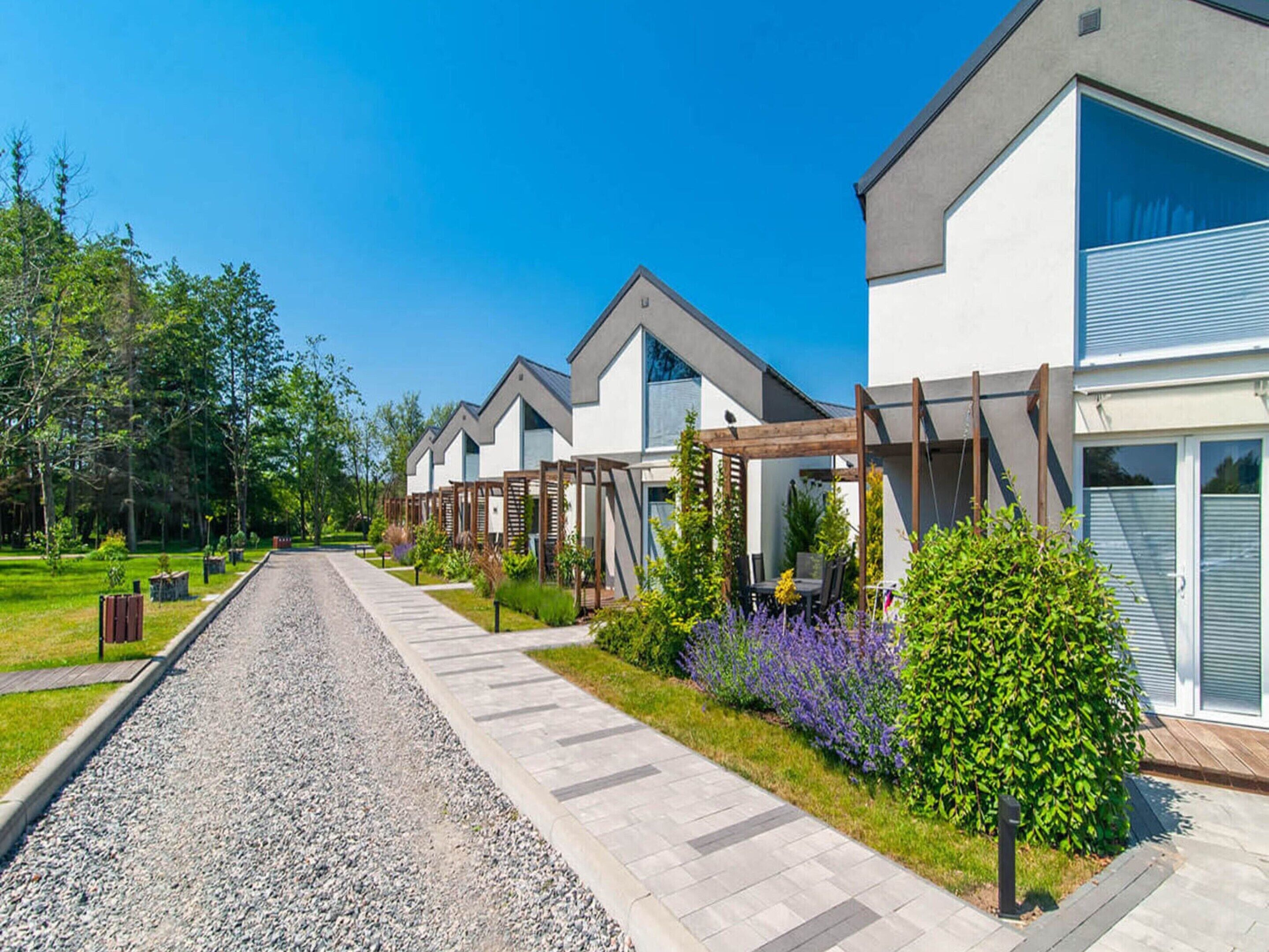 Una hilera de casas modernas con entrada de grava y jardines bien cuidados.