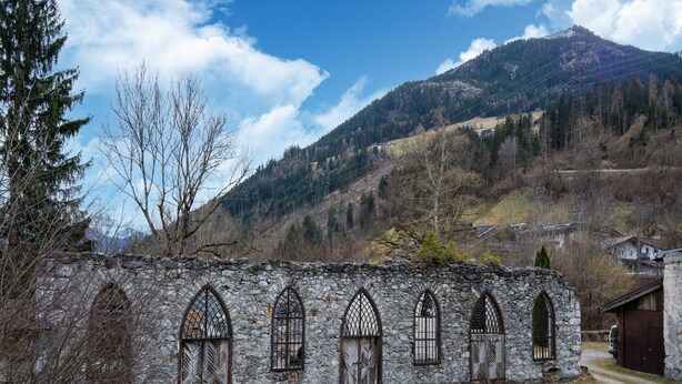 A stone building with arched windows and a door, surrounded by trees and a mountain in the background. - Apartment in Fugen Near Spieljochbahn (Fuegen)
