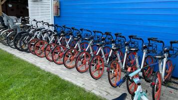 A row of bicycles parked against a blue building.