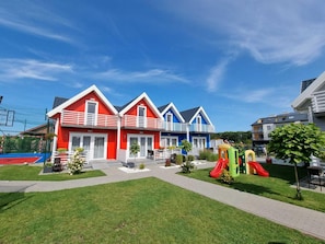 A row of colorful houses with a playground in the foreground.
