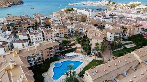 A coastal resort with multiple buildings, a central swimming pool, and a view of the sea. - Mazarron Coastal Apartment for 3 (Mazarrón)