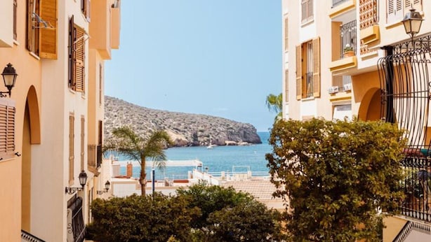 A coastal building with a view of the sea and a rocky island. - Mazarron Coastal Apartment for 3 (Mazarrón)
