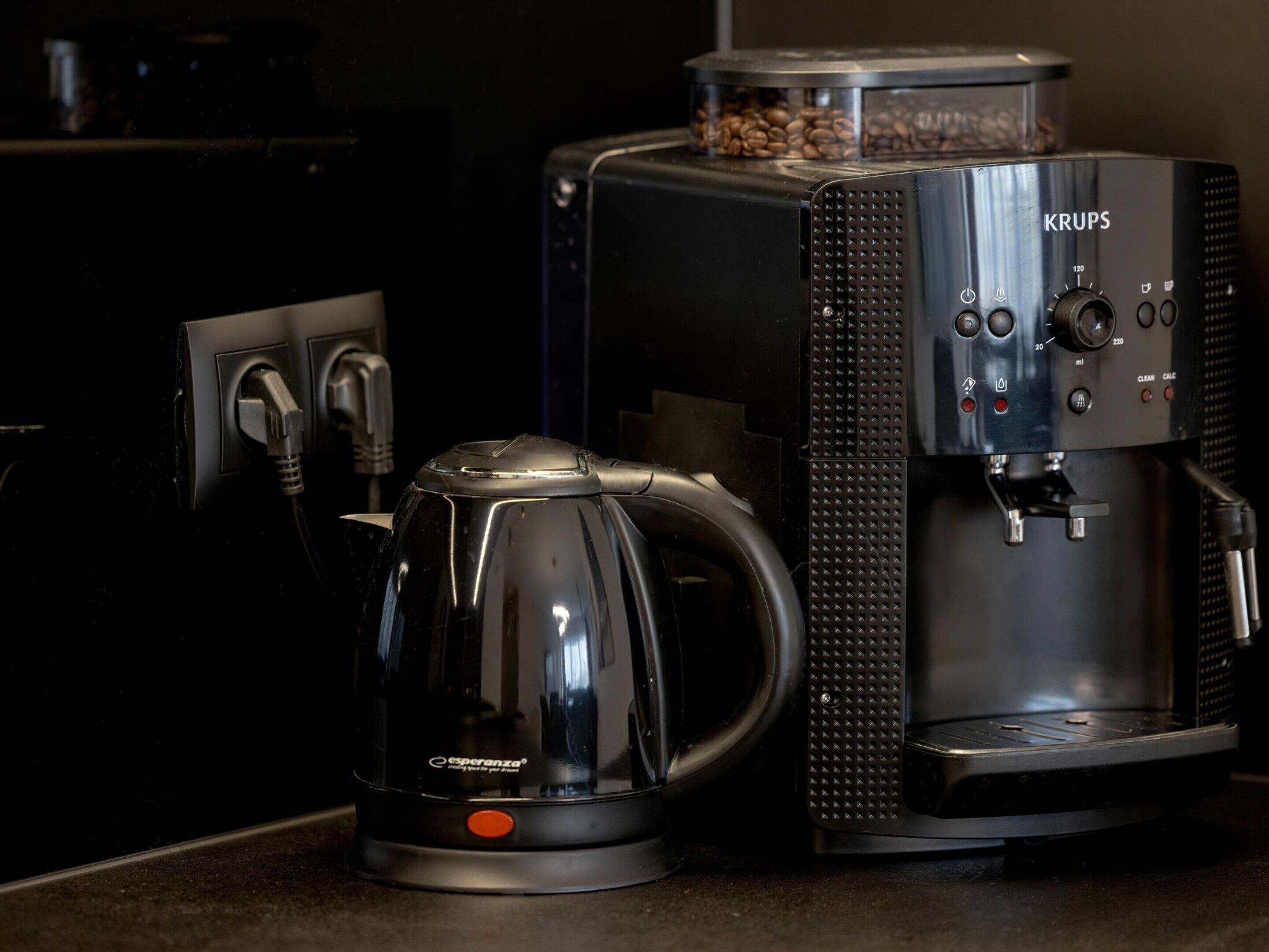 Una cafetera y una jarra de café sobre una encimera de cocina.