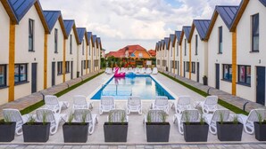 A row of modern, single-story buildings with a swimming pool in the center. - Cottage in Rewal Near Baltic Sea Beach (Rewal)
