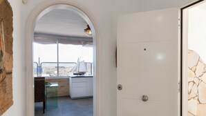 Une chambre moderne avec une grande fenêtre, une maquette de voilier et un mur en pierre.