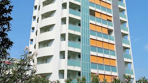 A multi-story hotel with balconies, a central atrium, and a modern architectural design. - Apartments Torre del Sole, Bibione Spiaggia (San Michele al Tagliamento)