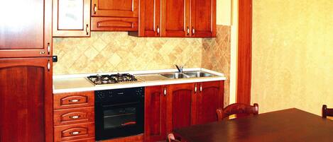A kitchen with wooden cabinets, a stove, a dishwasher, and a sink.