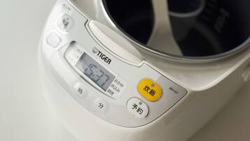 A rice cooker with a digital display and multiple buttons.