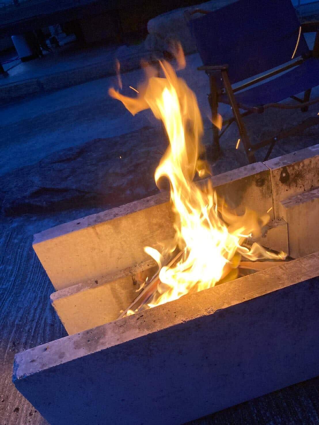 Fogo ardendo em uma estrutura de concreto.