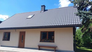 A single-story house with a tiled roof, a wooden door, and two windows with flower boxes. - Appartment, Wieliczka by Cracow (Wieliczka)