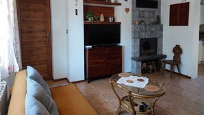 A living room with a television, fireplace, wooden cabinets, and a sofa. - Appartment, Wieliczka by Cracow (Wieliczka)