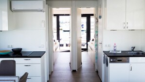 A modern kitchen with white cabinets, a dishwasher, and a countertop with a sink. - Hausboot in Boltenhagen (Boltenhagen)