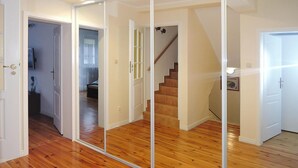 A room with wooden flooring, a mirrored closet, and a staircase. - Terraced House Near Baltic Sea & Wolinski Park (Międzyzdroje)