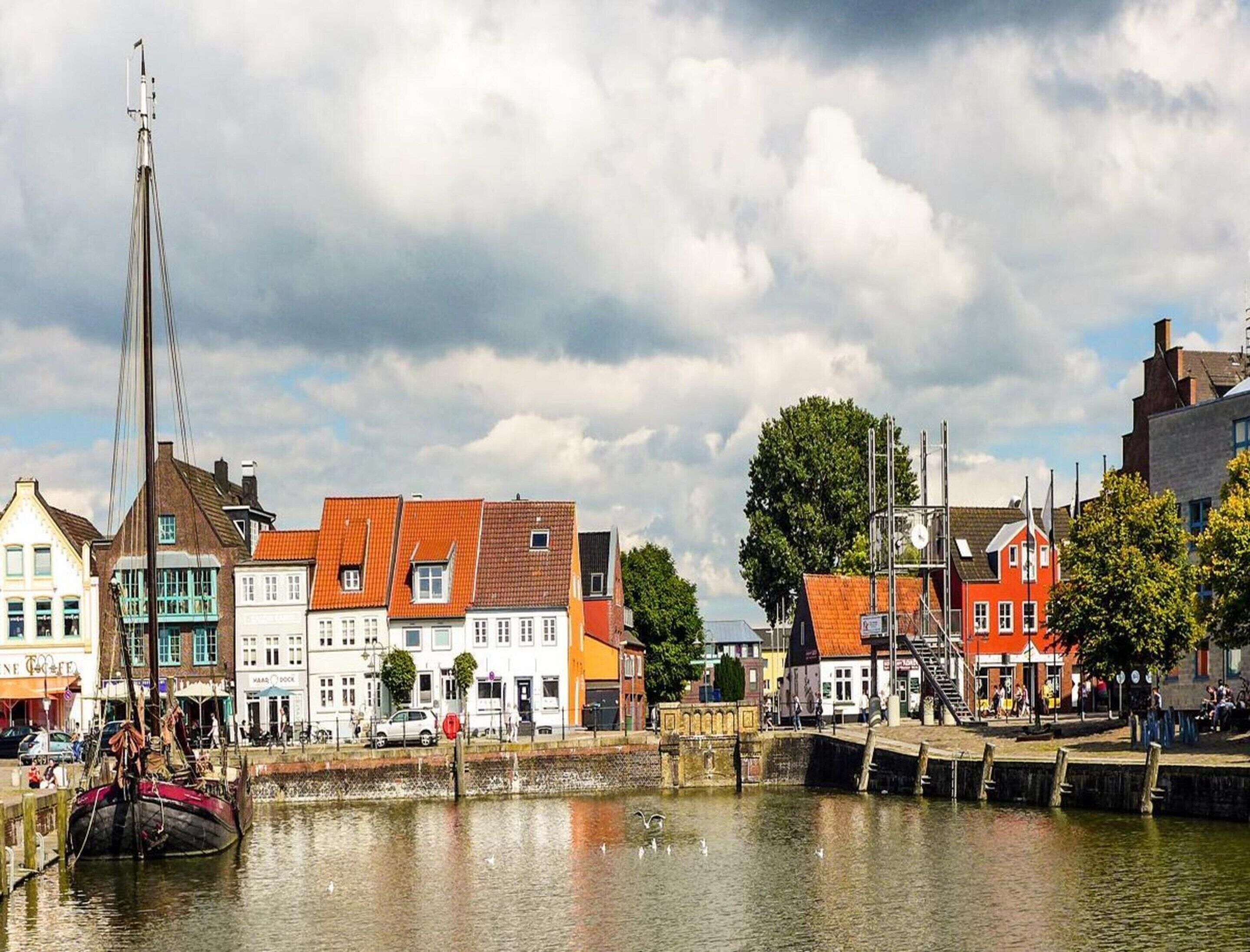 A waterfront area with buildings, a dock, and a crane.