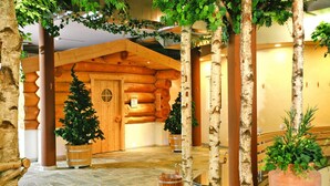 Un interior de estilo cabaña de troncos con paredes de madera, suelo de piedra y abedules.