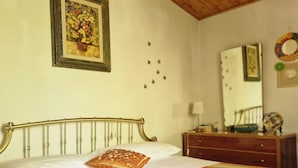 Une chambre à coucher avec un lit, une tête de lit en bois, une commode, un miroir et un tableau encadré accroché au mur.
