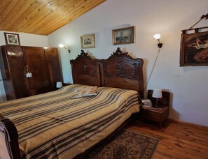 A bedroom with a wooden bed, a nightstand, a lamp, and framed pictures on the wall. - Farmhouse in Fano With Pool & Adriatic Views (Colli al Metauro)