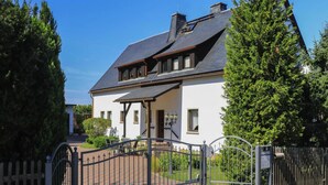 A two-story house with a dark roof, white walls, and a gated entrance. - Ferienwohnung Festungsblick in Pirna (Pirna)