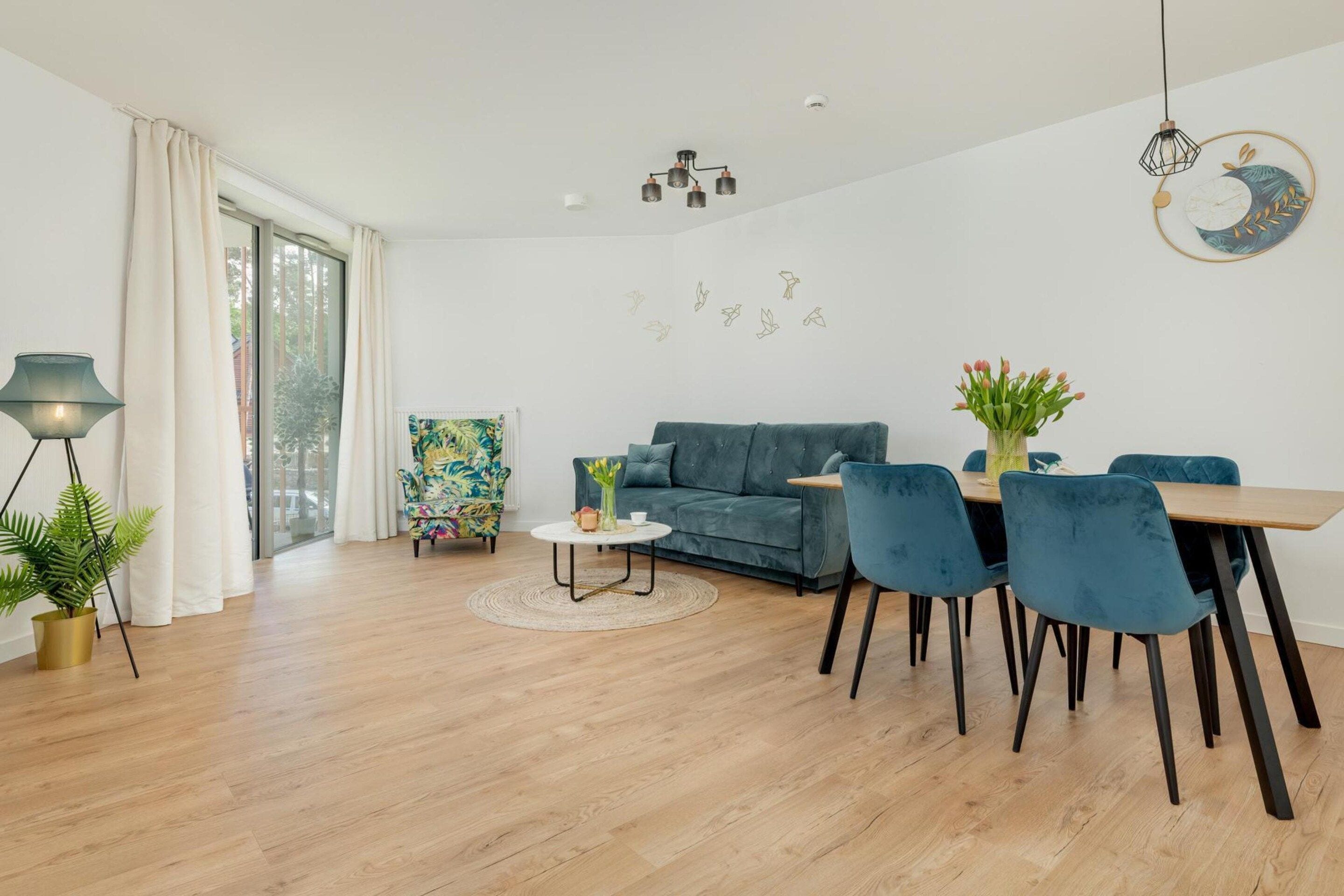 A modern living room with a sofa, chairs, a coffee table, and a dining area.