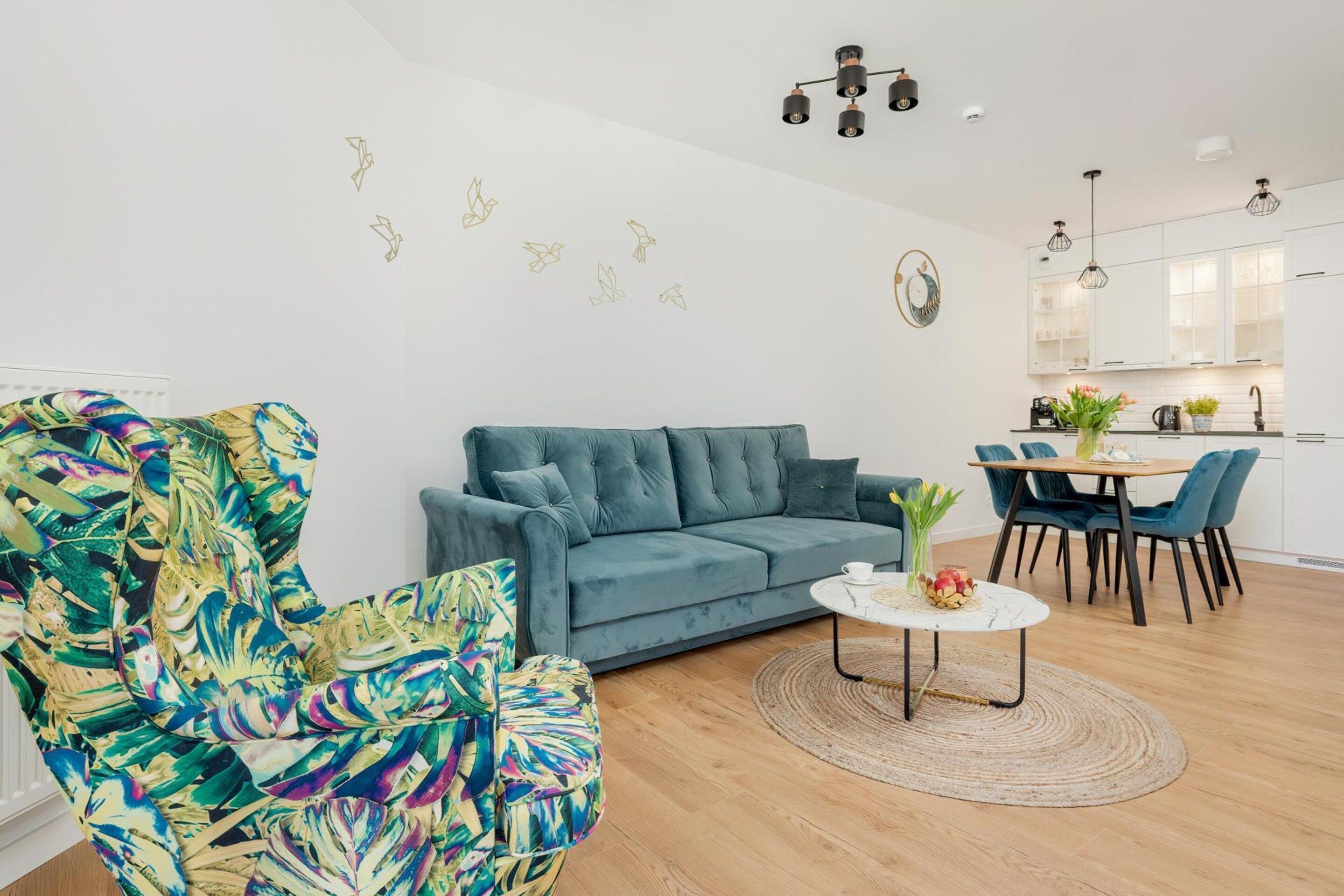 A modern living room with a sofa, a coffee table, and a vibrant armchair.