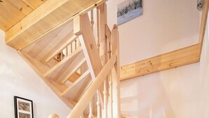 A wooden staircase with a handrail and a picture on the wall. - Chalet Hochkrimml With Sauna on the ski Slope (Krimml)