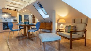 A loft-style living space with a dining area, a sofa, and a skylight. - Wohnung in St.peter Ording (St. Peter-Ording)