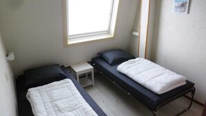 A small room with two single beds, a small table, a window, and a picture on the wall. - House in Breskens near Scenic Beaches (Breskens)