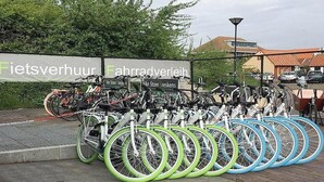 A bicycle parking area with a sign for 'Fietsverhuur Fabradvlei' and a bike store named 'Bike Store Breuksens'. - Waterfront Bungalow Near Beach (Breskens)