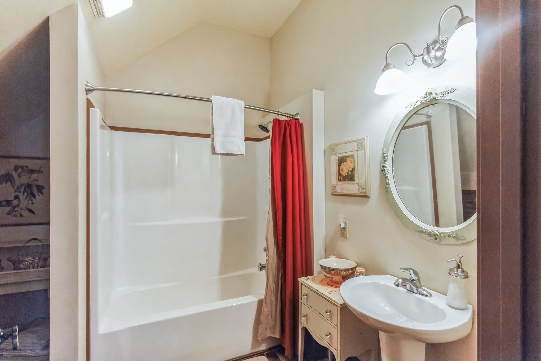 A bathroom with a bathtub, a sink, a mirror, and a shower curtain.