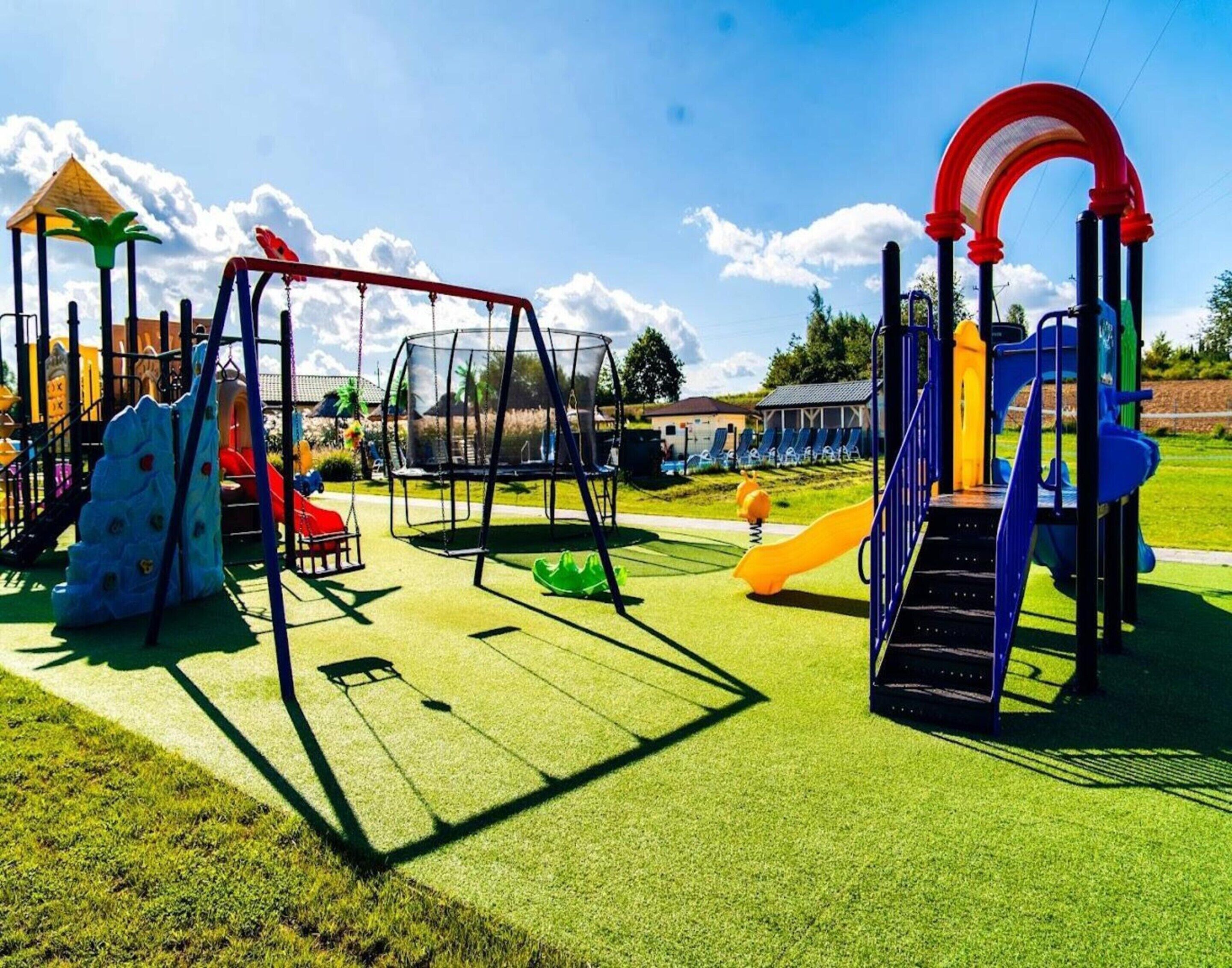 A playground with various play structures including slides, swings, and climbing areas.