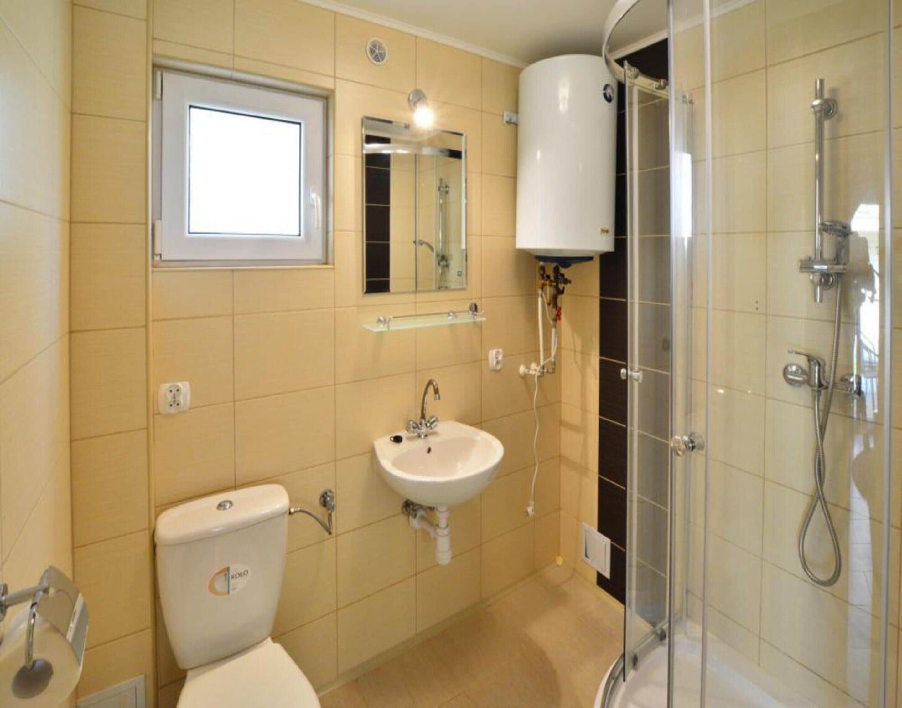 A bathroom with a toilet, sink, and shower.