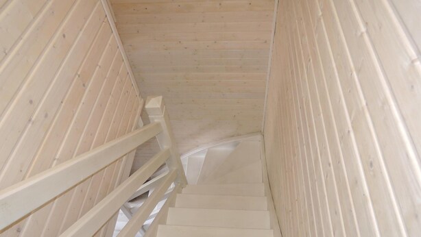 A wooden staircase with white railings leading upwards.