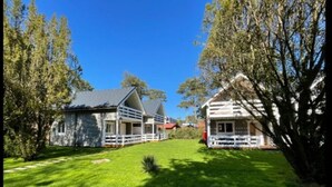 A two-story house with a fenced yard and a well-maintained lawn. - House for 6 With Swimming Pool (Trzebiatow)