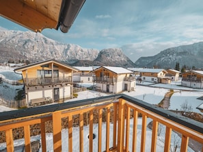 A snow-covered mountain village with wooden houses and a wooden balcony railing. - Chalet Alpenzauber mit Beheiztem Pool, Inzell (Inzell)