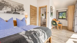 Un dormitorio con cama, escritorio y vistas al exterior.